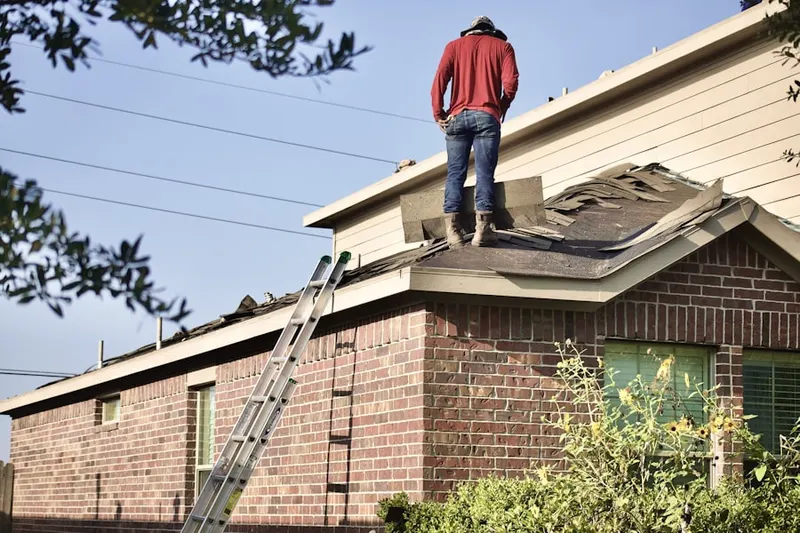 Professional roofer working on a residential roof in Buena